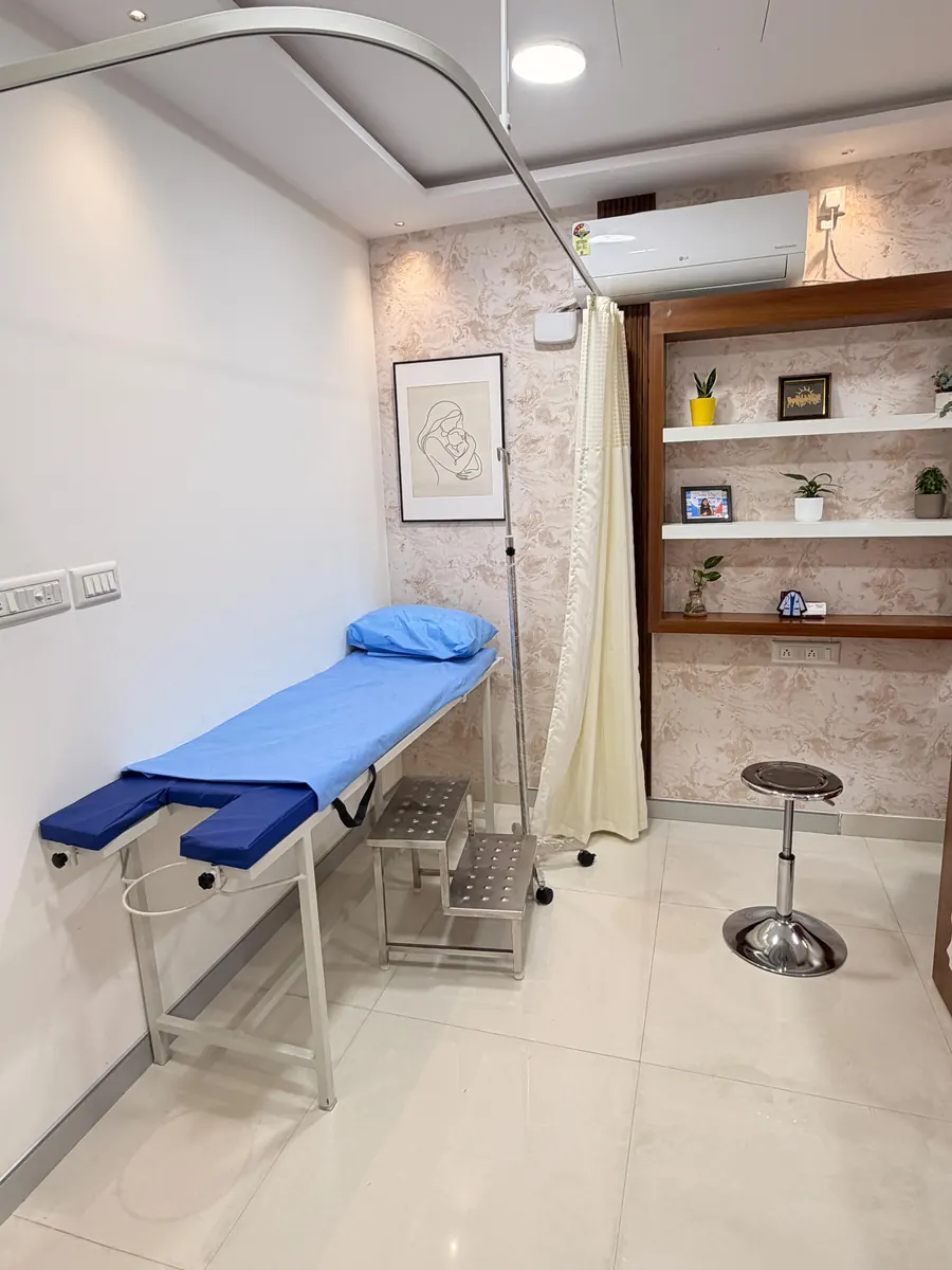 An examination couch with a privacy curtain and step stool